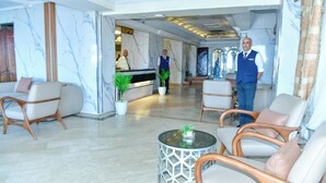 A hotel lobby with marble walls, a reception desk, and seating areas. - Regency Hotel Alexandria (Alexandria)