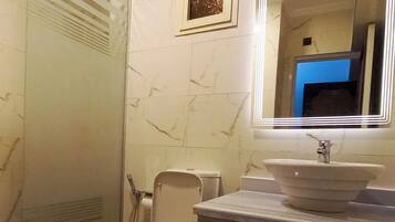 A bathroom with a toilet, a sink, and a shower.