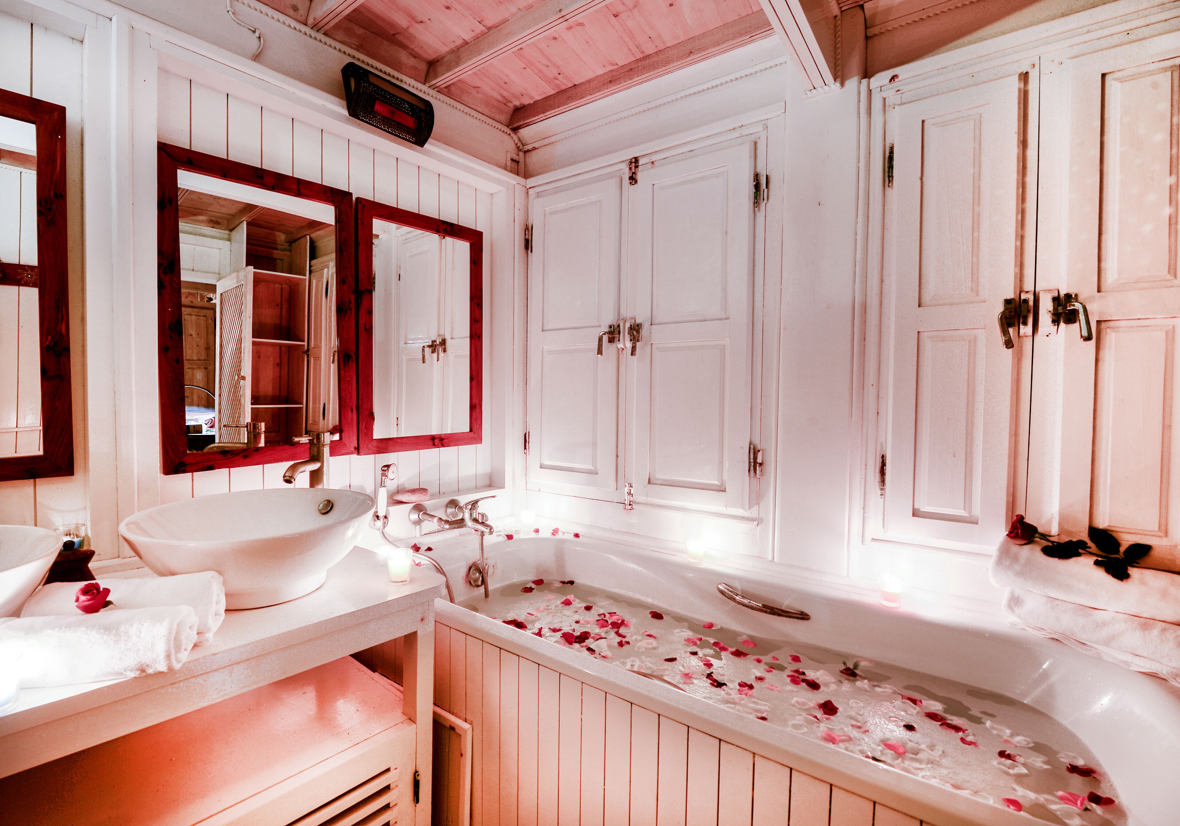 A bathroom with a large bathtub, a sink, and a mirror.