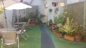 A small courtyard with artificial grass, a narrow path, and potted plants. - Hotel Uruguay (Montevideo)