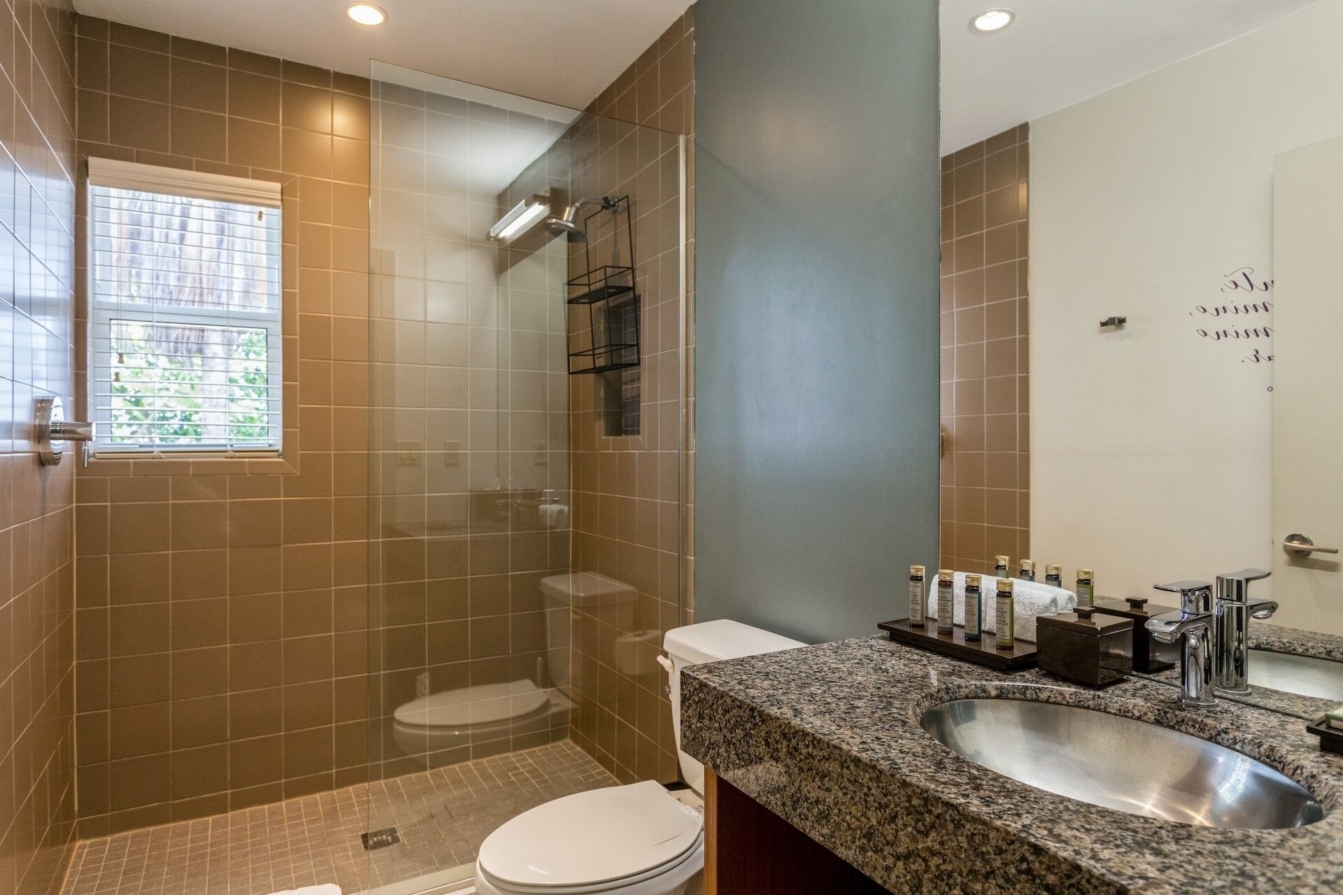 A bathroom with a shower, toilet, and sink.