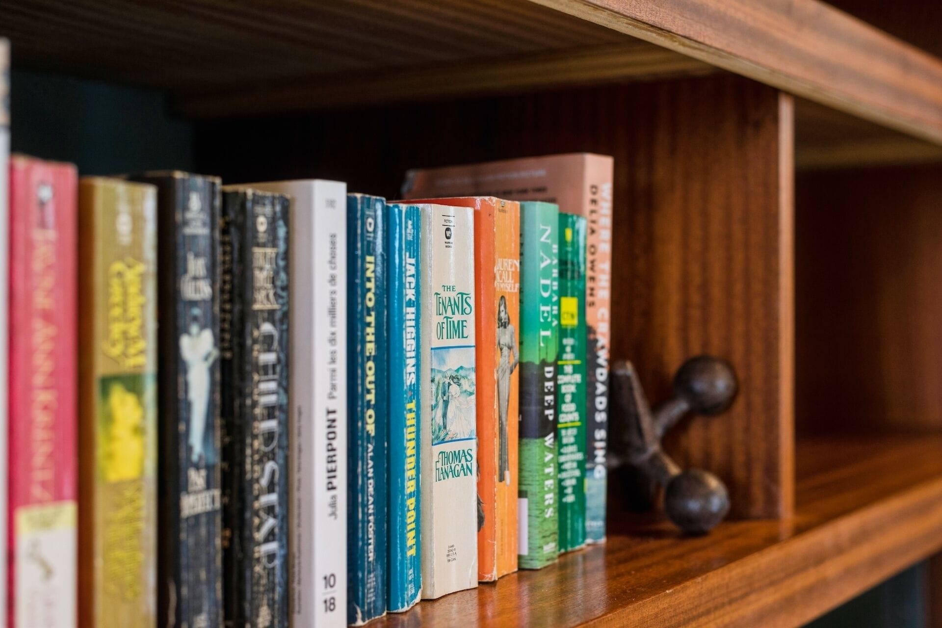 A bookshelf with a variety of books, including titles like 'Into the Out of Time' and 'The Tenants of Time'.