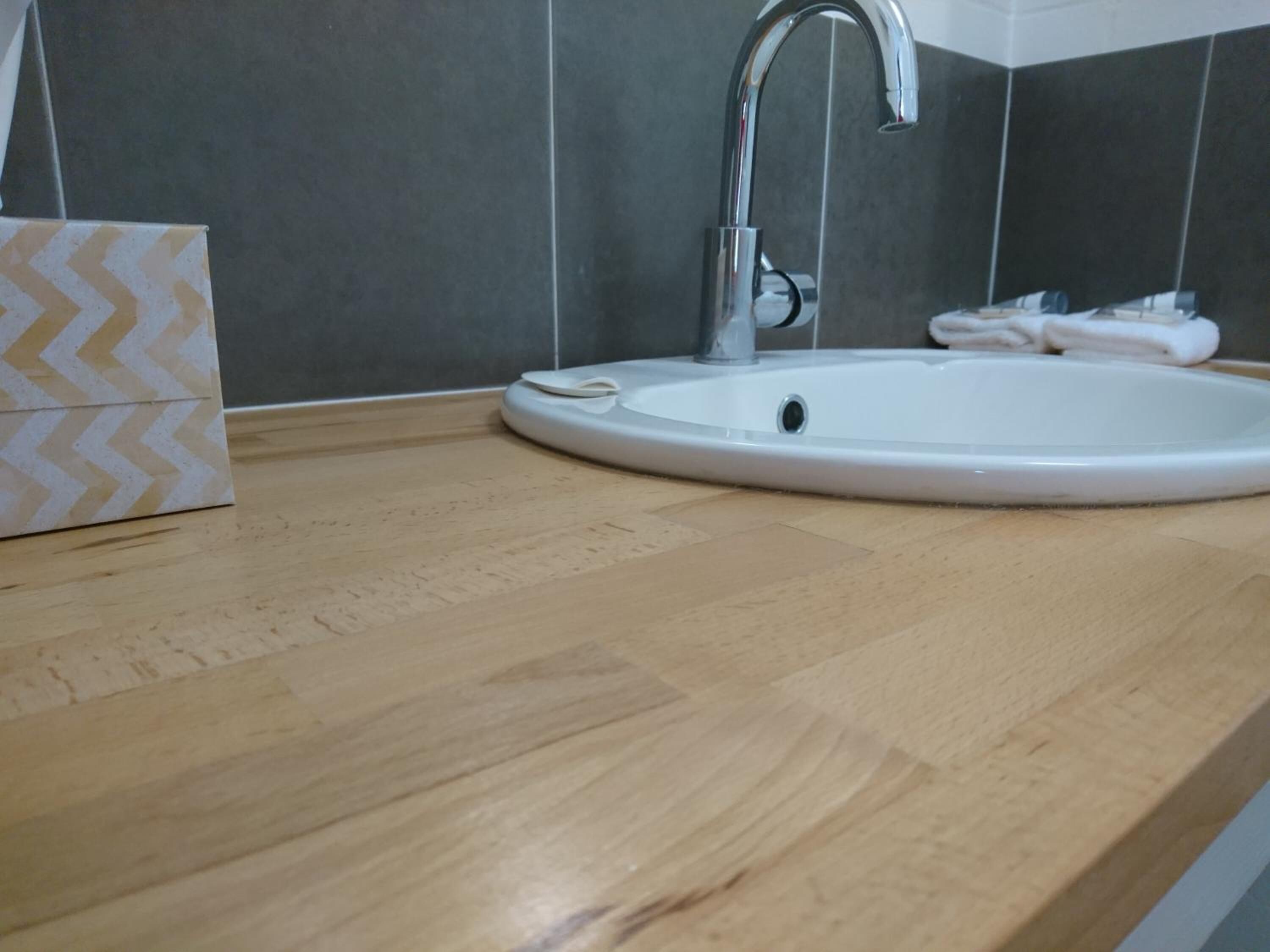 A bathroom with a white sink, a mirror, and a towel rack.