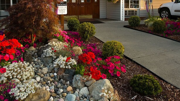 A hotel entrance with a sign reading "The Marina Club," a no smoking sign, and a parking sign. - The Marina Inn (Anacortes)
