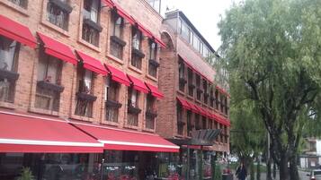 Un edificio de ladrillo con toldos rojos y numerosas ventanas.