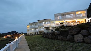 Vista frontal de la propiedad por la tarde o noche