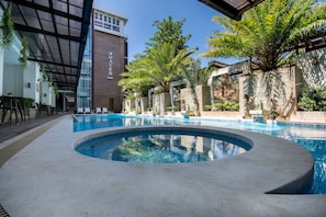 Una piscina al aire libre, tumbonas