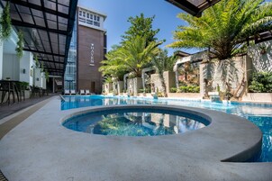 A swimming pool with a circular hot tub, surrounded by palm trees and a building labeled "Haven."