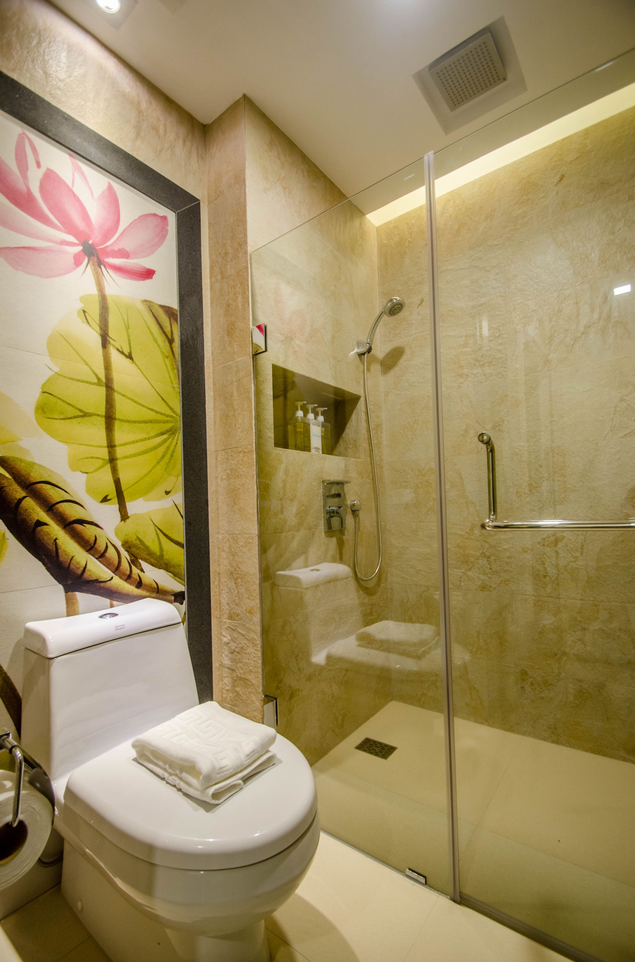 Un baño moderno con ducha de vidrio, inodoro y secador de manos.