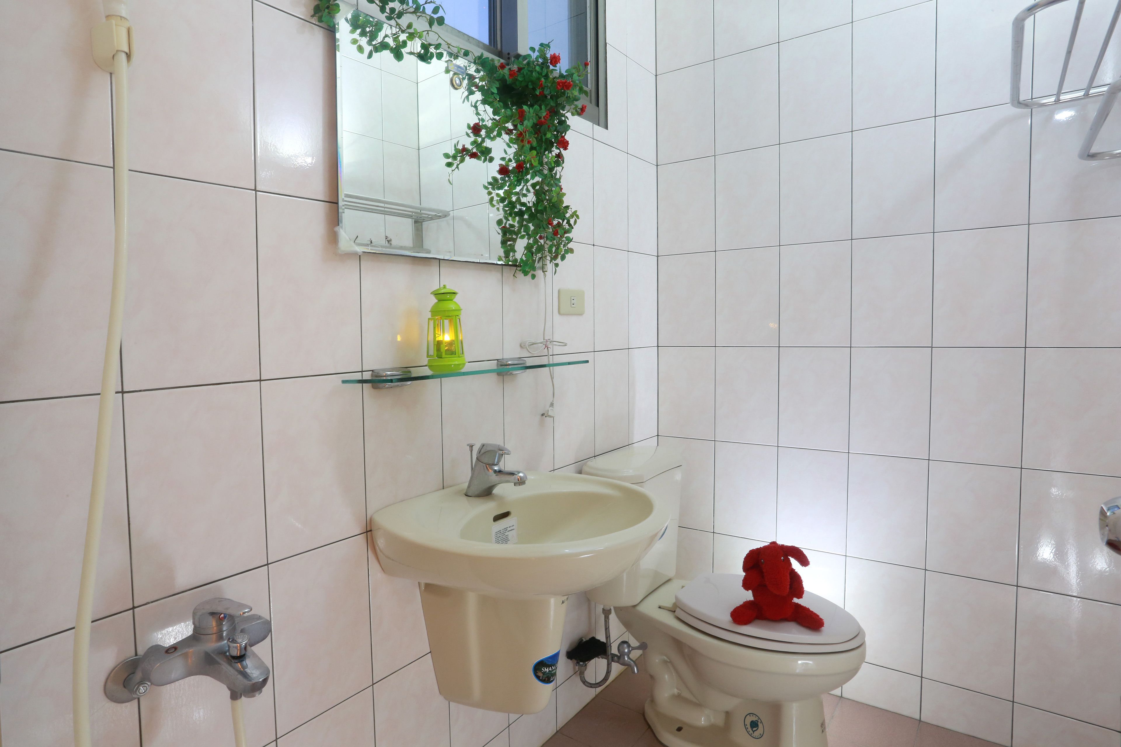 A bathroom with a sink, toilet, and a mirror.