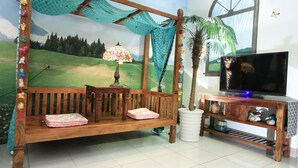 A room with a wooden swing bed, a television on a cabinet, a lamp, and a large window with butterflies.