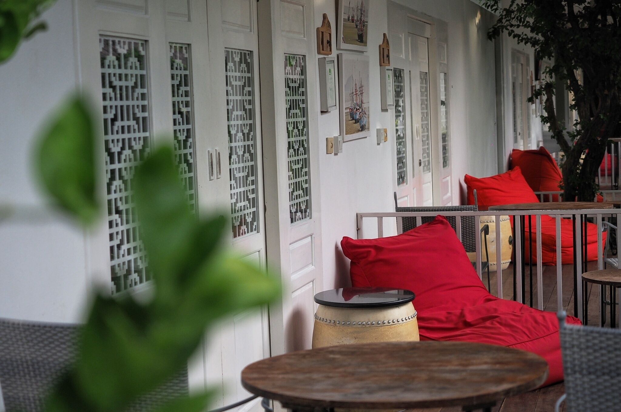 A room with a round table, red cushions, a drum, and decorative doors.