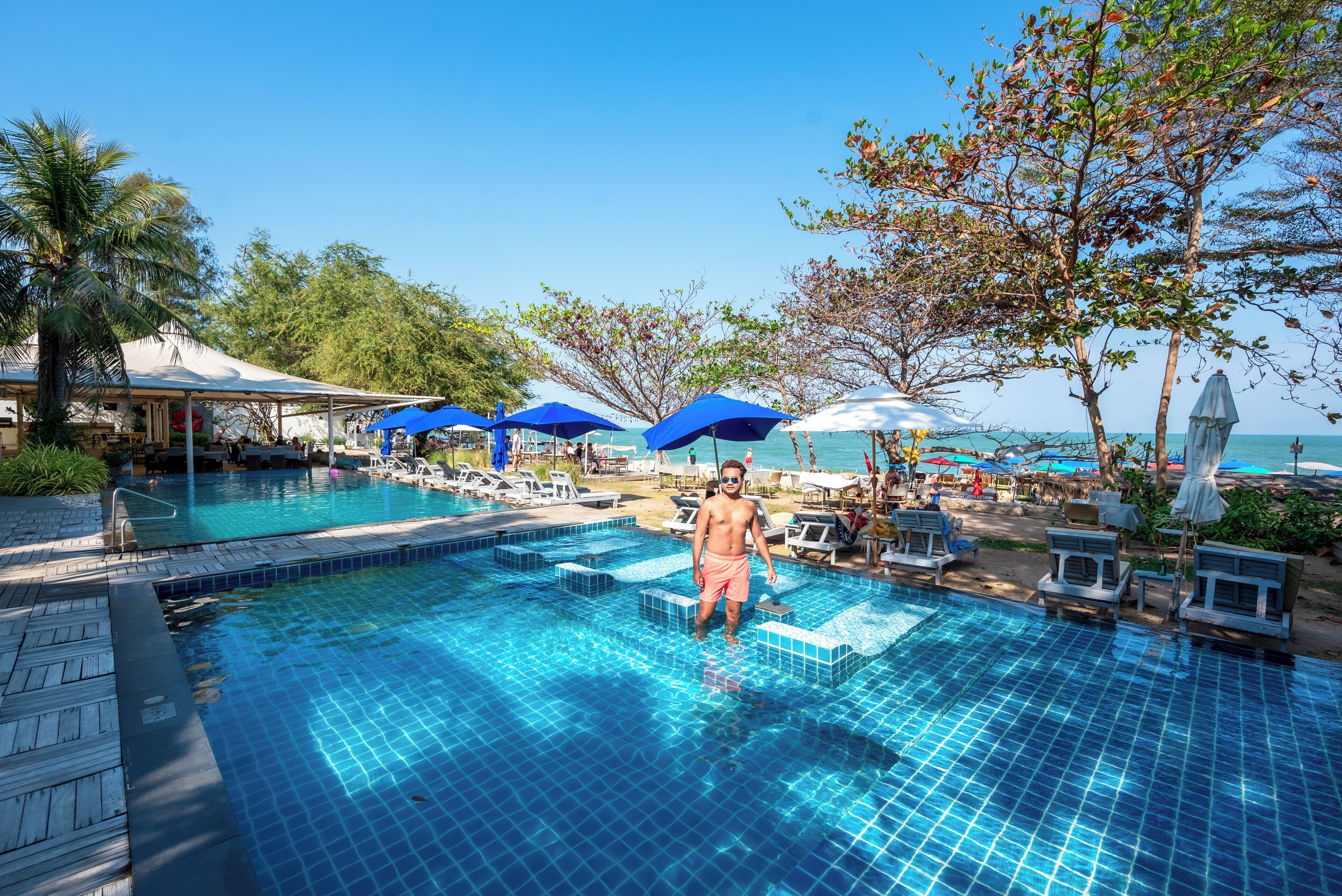 Alberca al aire libre, sombrillas en la alberca y camastros 