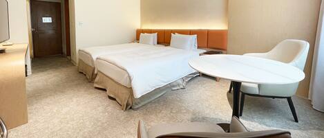Une chambre d’hôtel avec un grand lit, un bureau, une chaise et un téléviseur.