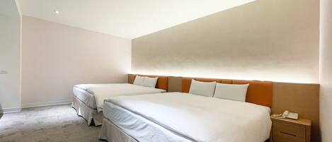 A hotel room with two beds, a nightstand with a phone, and a light fixture on the ceiling.