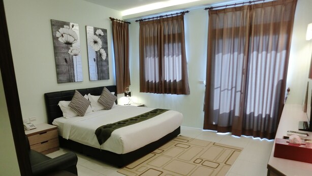 A neatly arranged bedroom with a bed, bedside tables, a nightstand, a desk, and a chair. - Love Play House (Luodong)