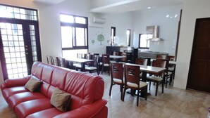 A spacious living area with a red leather sofa, dining table, and chairs. - Love Play House (Luodong)