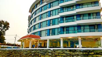 A multi-story hotel with a stone facade and a covered entrance area.