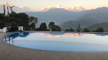 Outdoor pool, an infinity pool, pool umbrellas, sun loungers