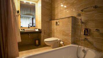 Un baño moderno con bañera, inodoro y tocador con espejo.