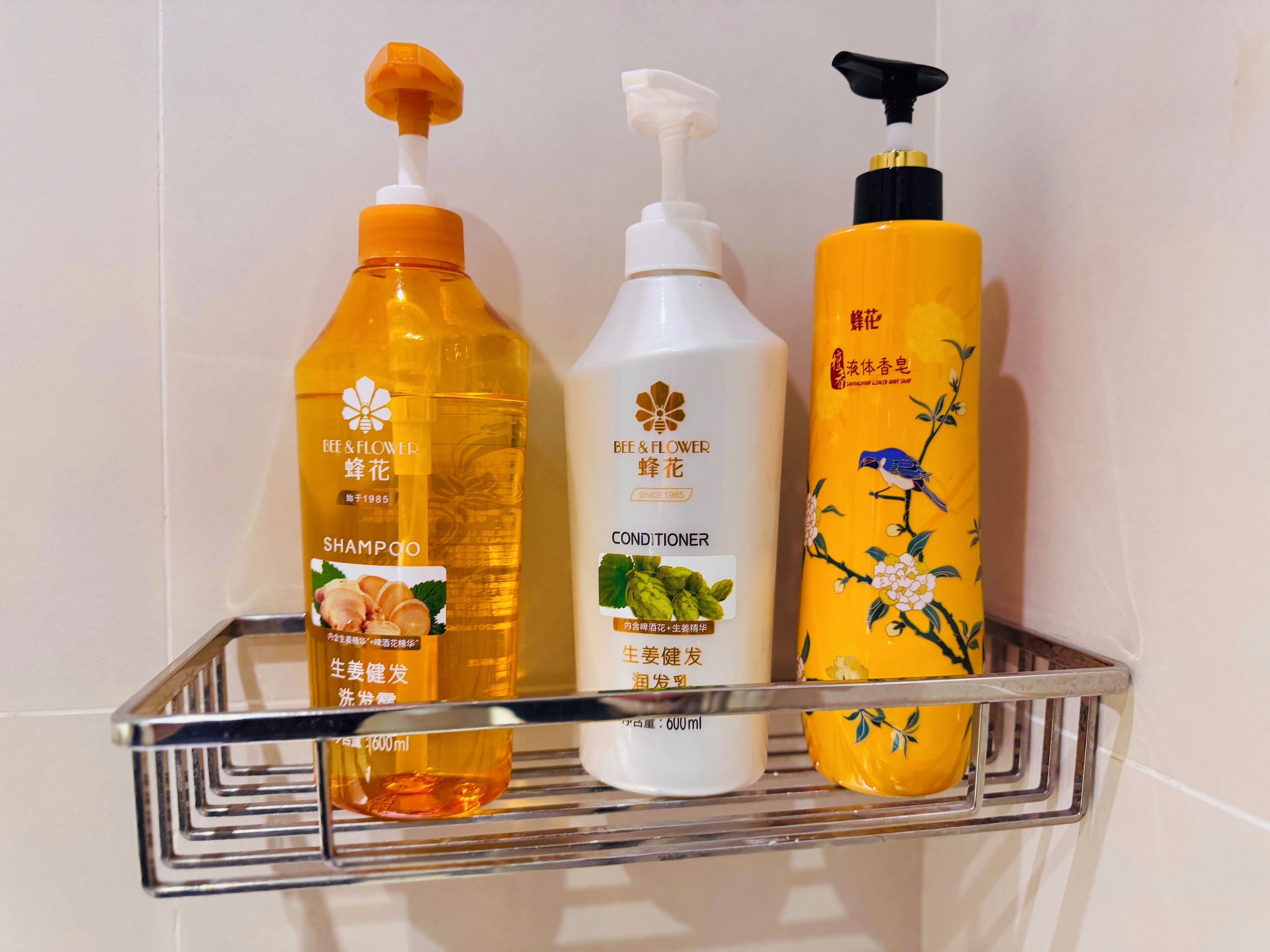 Three bottles of personal care products on a metal shelf.
