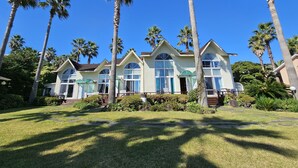 A resort with multiple villas, palm trees, and a well-maintained lawn. - Old Man and Sea Pension (Seogwipo)