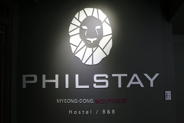 A sign for 'PHILSTAY' with a stylized lion's head logo, indicating a hostel or boutique hotel. - Philstay Myeongdong Boutique - Hostel (Seoul)