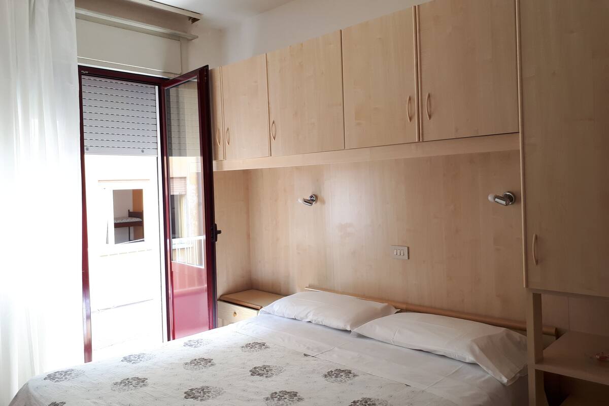 Un dormitorio con una cama, un armario de madera y una mesita de noche.