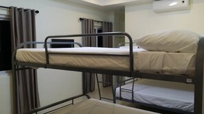 A bunk bed room with a window, curtains, and a wall-mounted air conditioner. - Villa Del Faro (Calatagan)