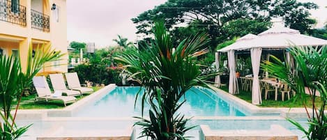 Una piscina al aire libre, tumbonas