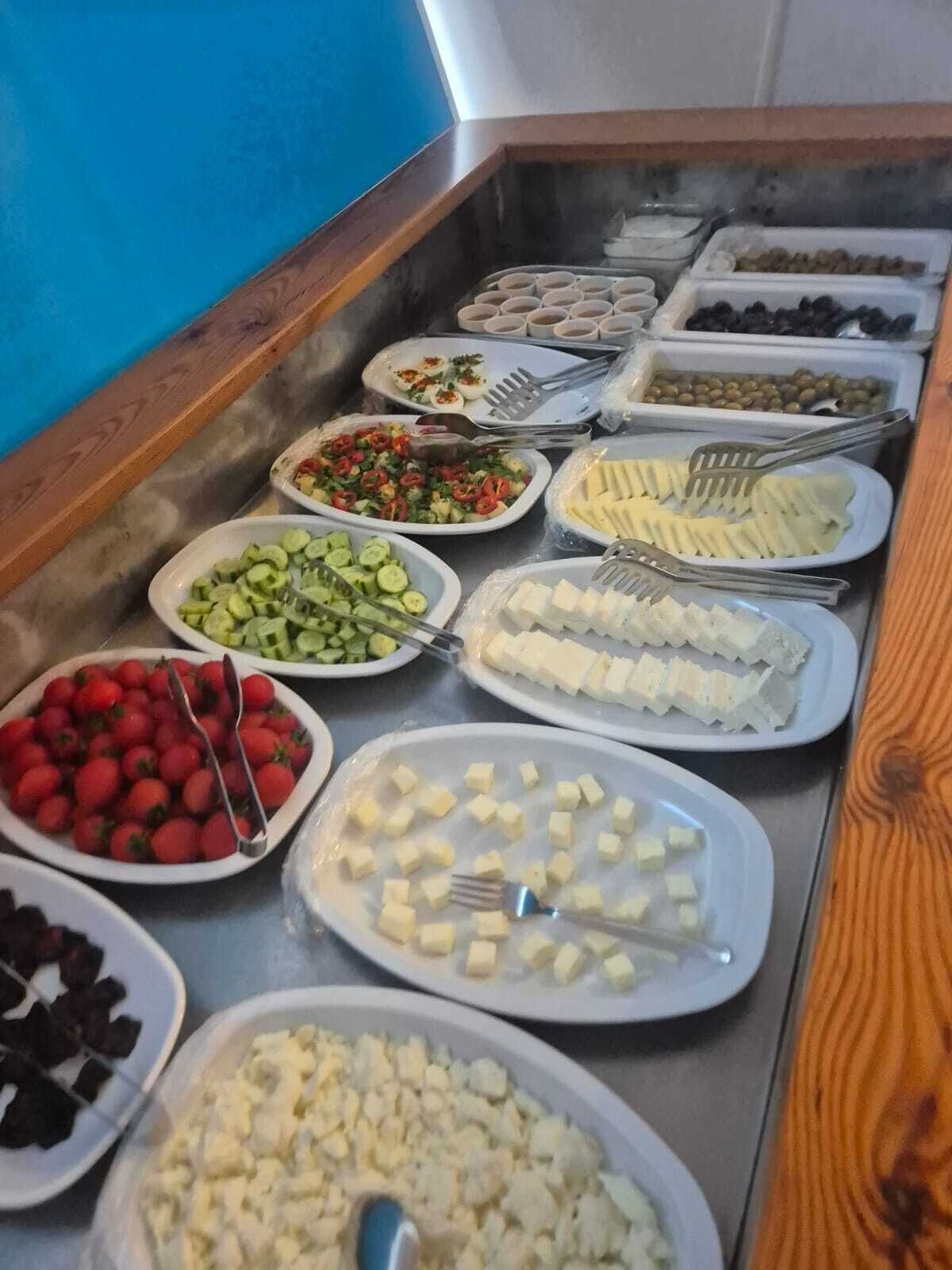 Un bufé con diversos alimentos, incluyendo frutas, verduras y queso.