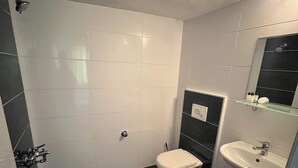A bathroom with a toilet, sink, and mirror. - Cihanay Hotel (Antalya)