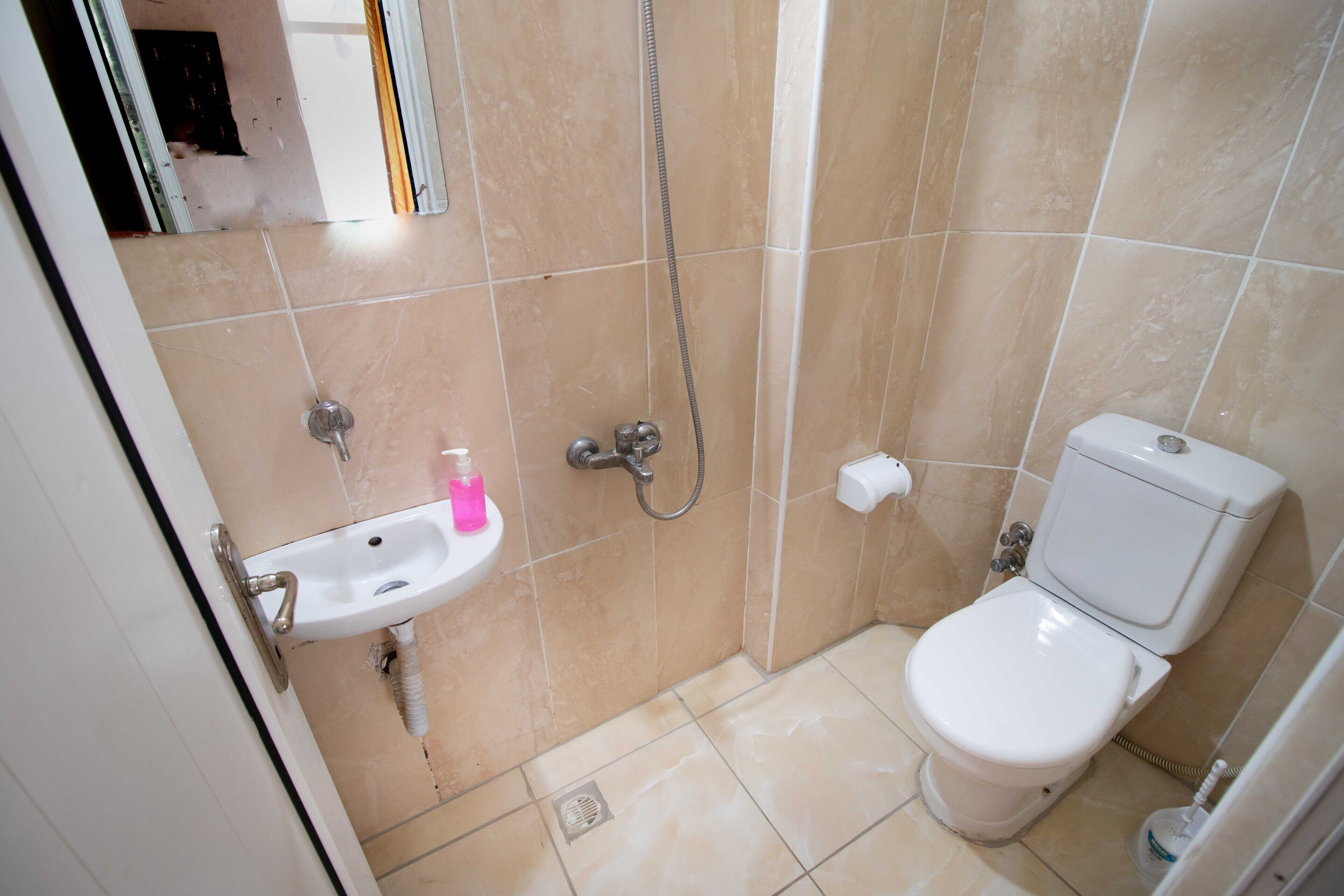 A small bathroom with a sink, toilet, and shower.