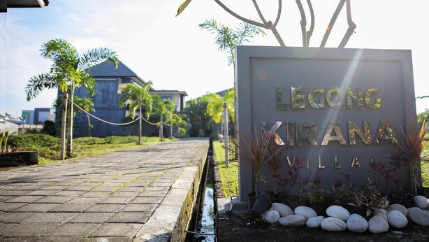 Placa de Leong Kirana Villas com um caminho pavimentado e vegetação ao fundo.