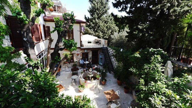 Un patio con mobiliario exterior, una fuente y plantas en macetas.