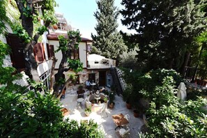 Une cour avec des sièges en plein air, une fontaine et des plantes en pot.