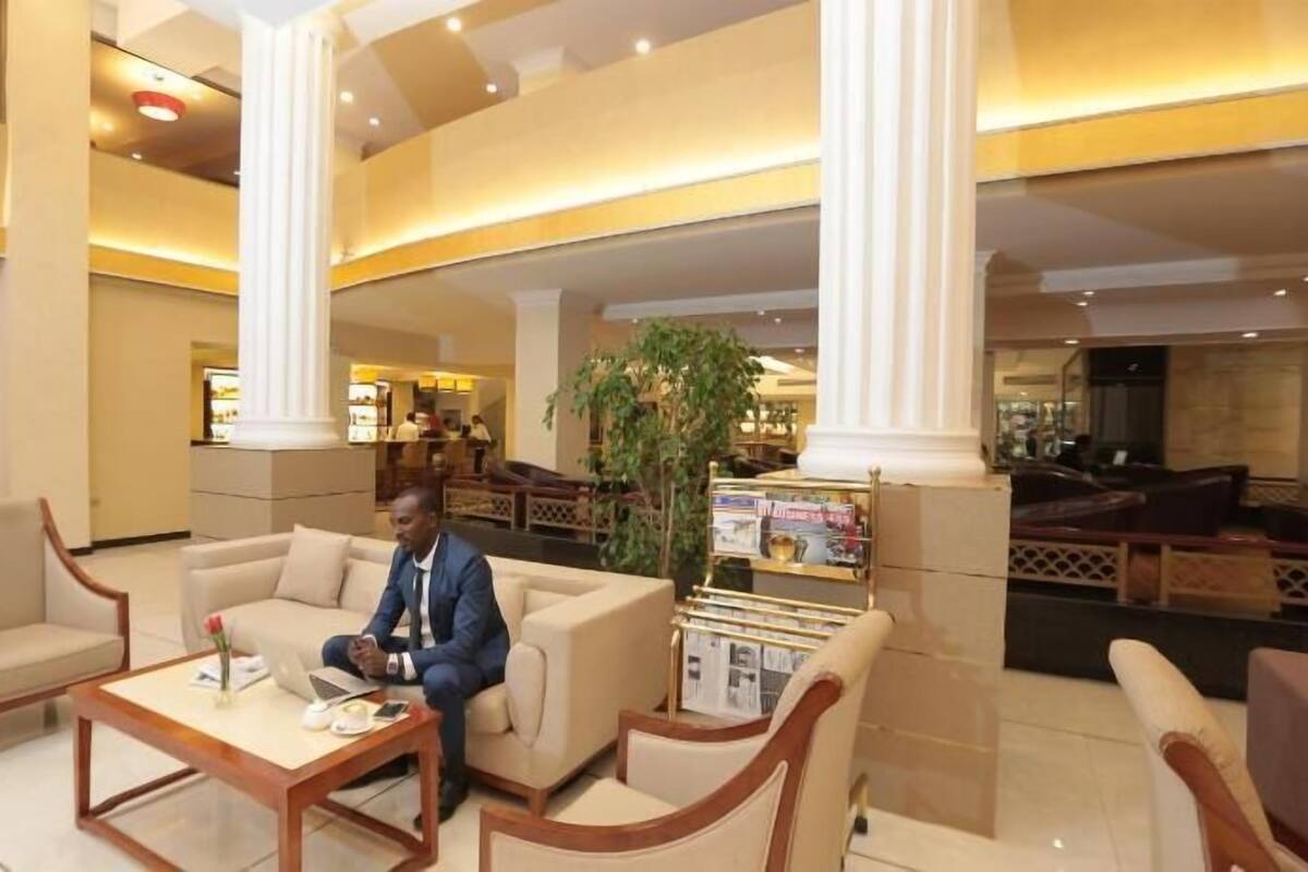 A lobby with a seating area, a reception desk, and a large plant.
