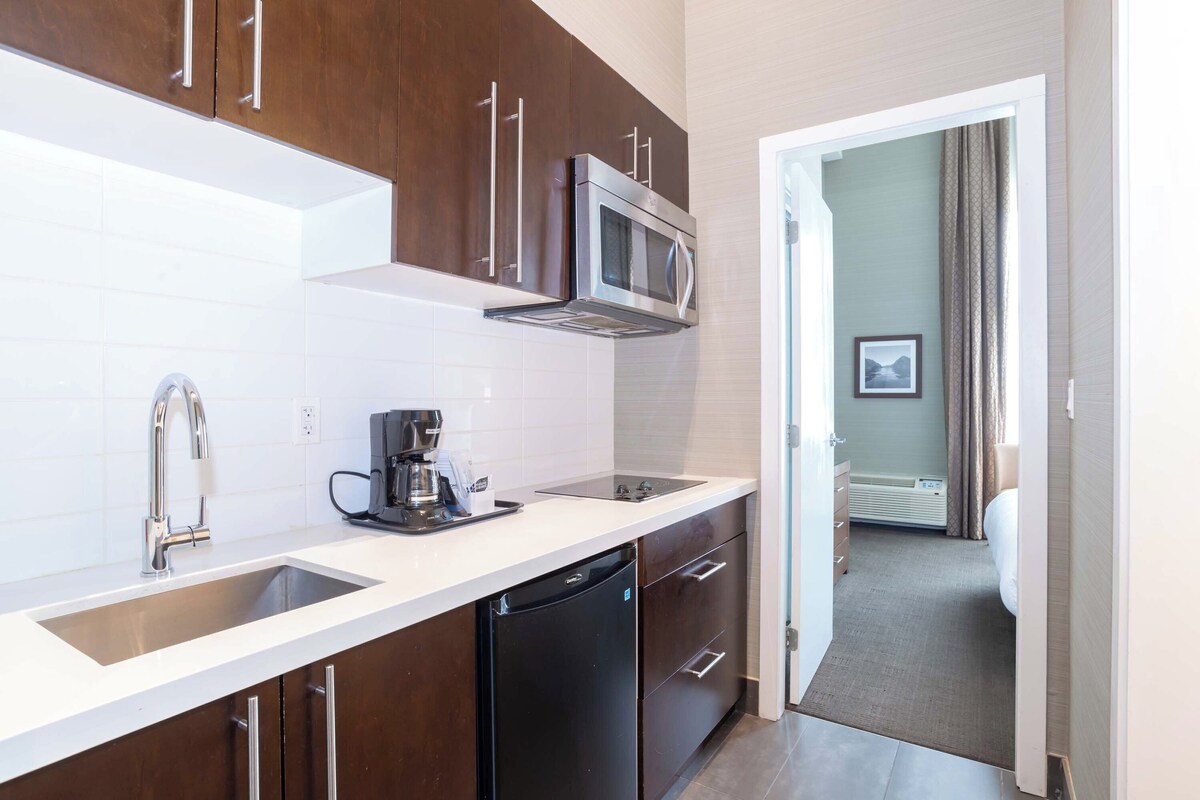 A modern kitchen with stainless steel appliances, a dishwasher, and a coffee maker.