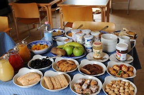 A table with various food items and drinks, including fruits, pastries, and condiments. - La Casa Blu Bed & Breakfast (Calliano)
