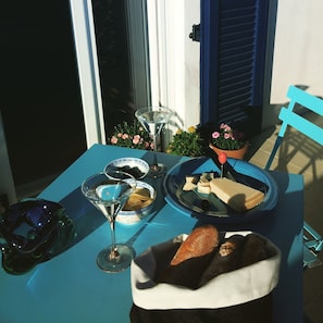 A table set with a martini glass, a bowl of olives, a plate of cheese, and a basket of bread. - La Casa Blu Bed & Breakfast (Calliano)