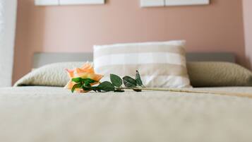 Ein Bett mit einer einzelnen Rose und einem Kopfkissen.