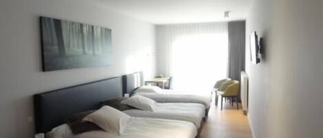 Una habitación de hotel con una cama grande, un escritorio y una silla.