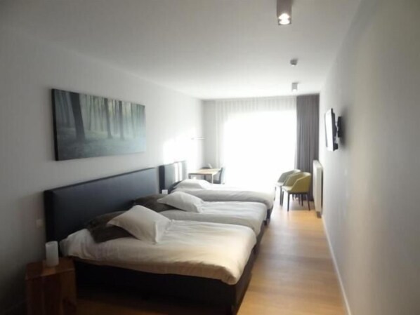 Una habitación de hotel con una cama grande, un escritorio y una silla.