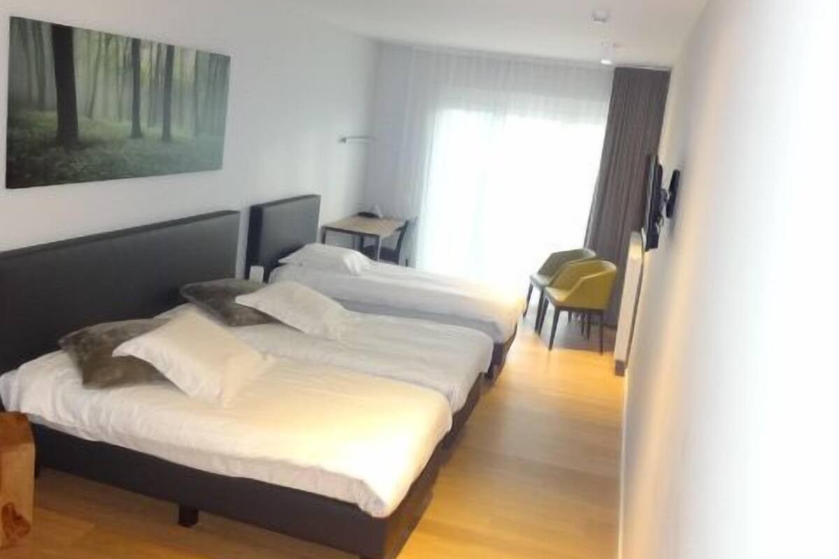 Een moderne hotelkamer met een groot bed, een bureau en een stoel.