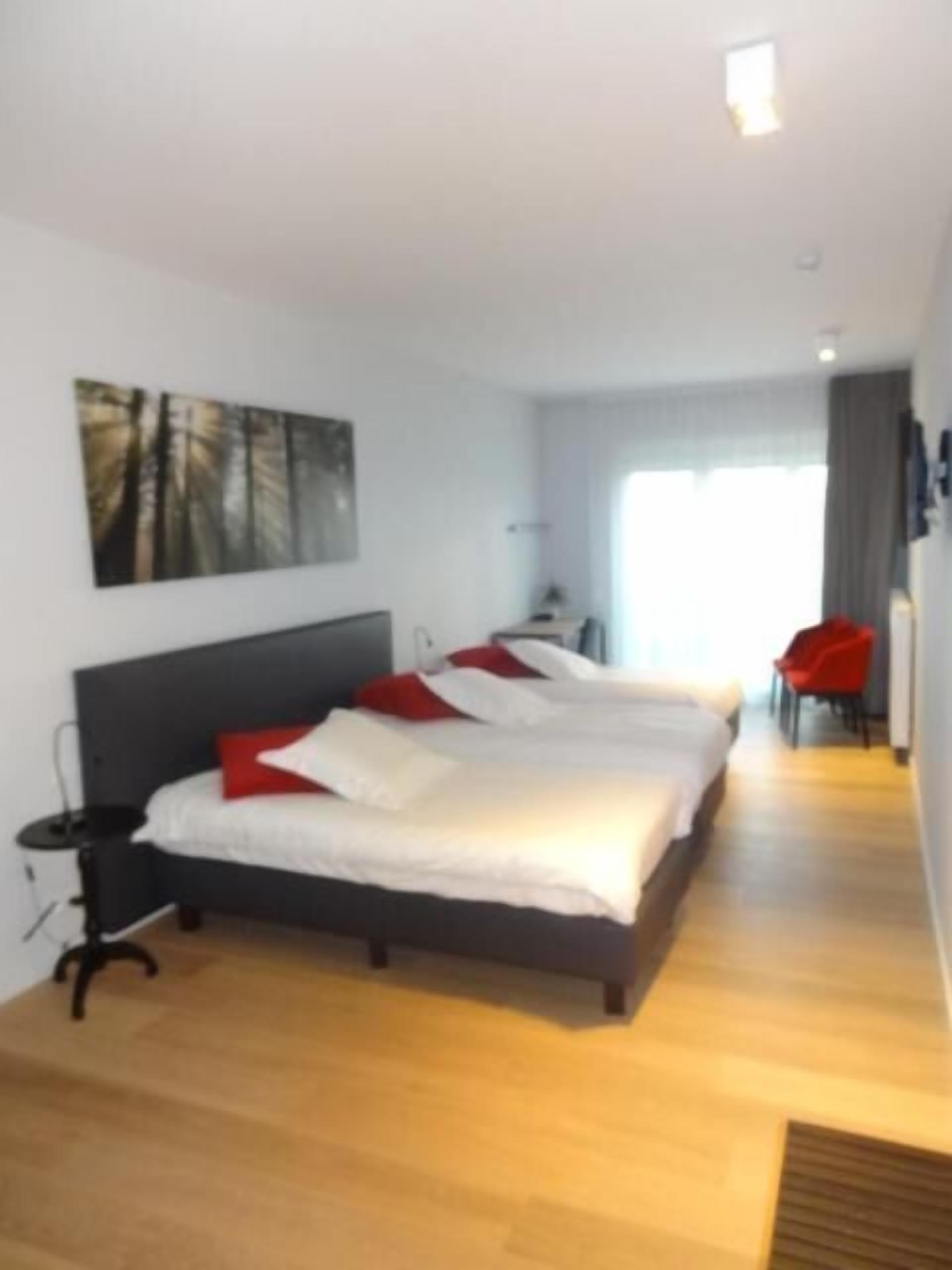 Ein modernes Hotelzimmer mit einem großen Bett, einem Schreibtisch und einem Stuhl.