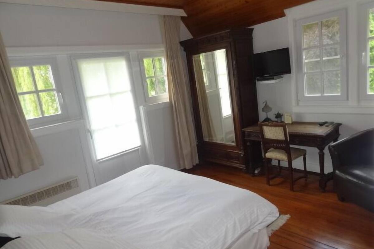 Een slaapkamer met een bed, een bureau, een stoel en een televisie.