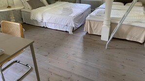 Un dormitorio con una cama con dosel, una cama individual, una silla y una mesa.