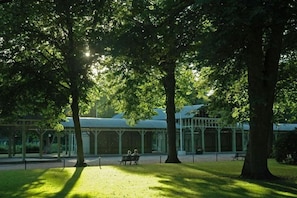 A park with trees, a gazebo, and a bench.