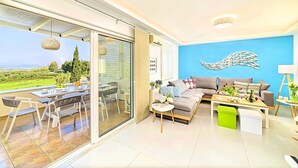 A modern living room with a sofa, coffee table, and dining area. - Cretan Mansion with Heated Swimming Pool (Apokoronas)