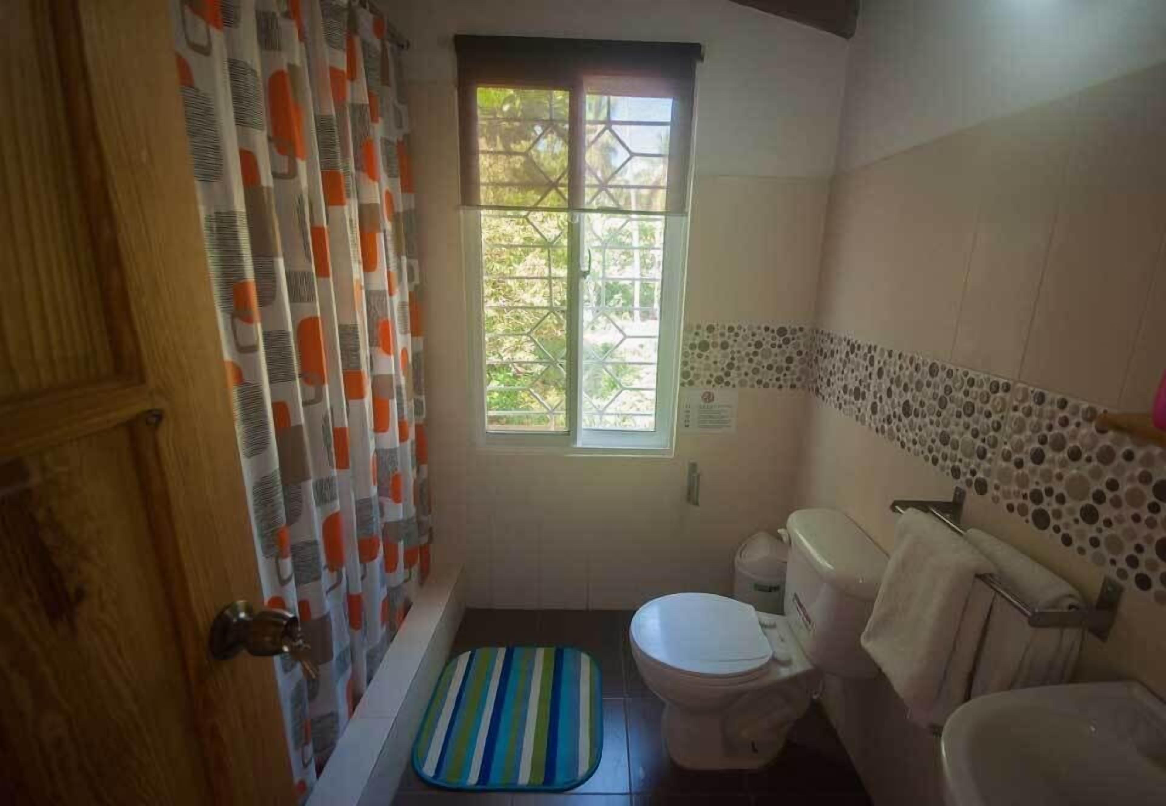 Un baño con bañera, inodoro y ventana.